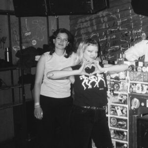 Dana and Kontaminierungsalarm in a black and white picture. Kontaminierungsalarm is forming a heart with the fingers and Dana is smiling.